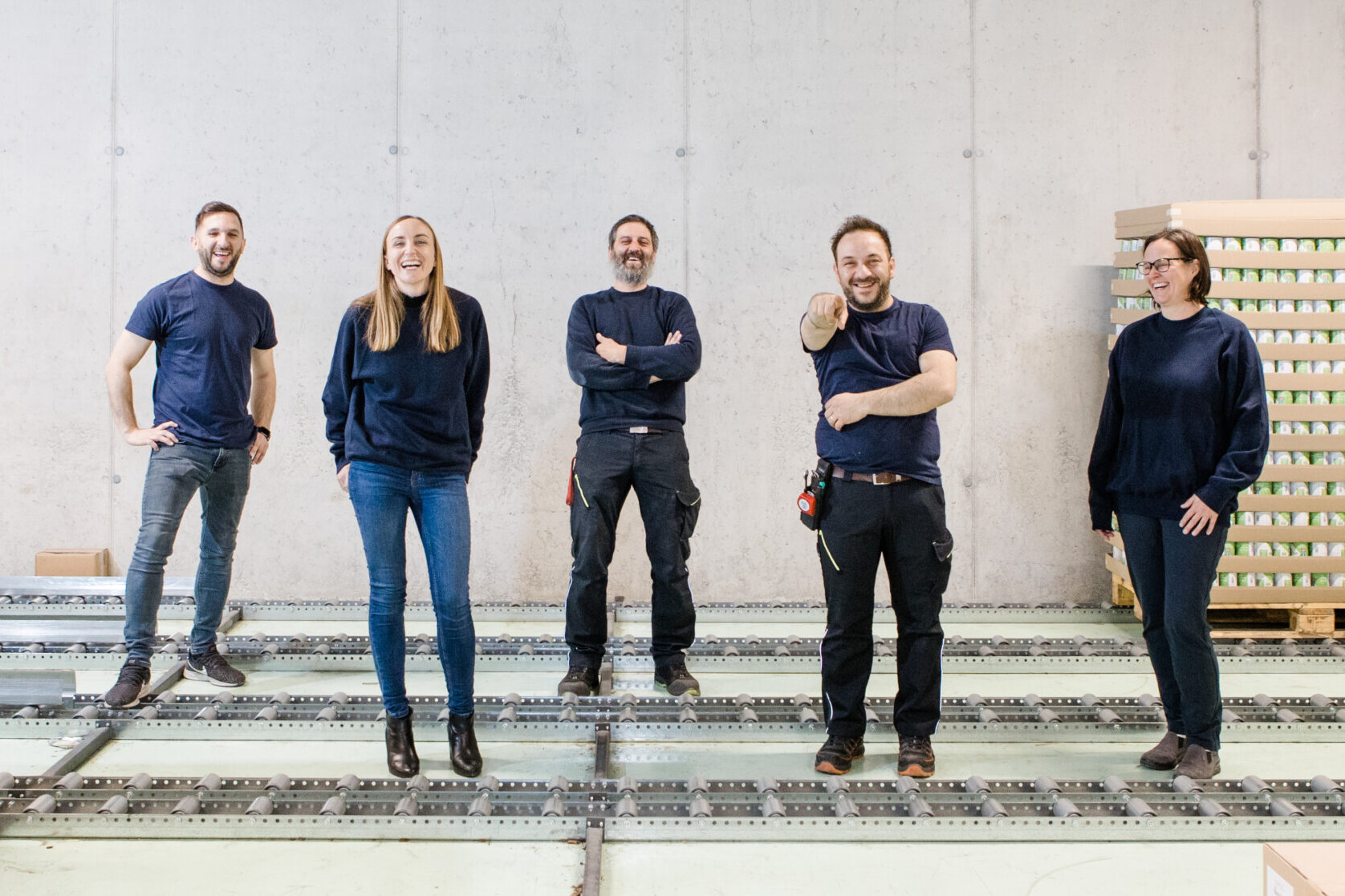Team pratopac for Sichtbetonwand in der Produktionshalle für Membrandosen und Schmuckdosen