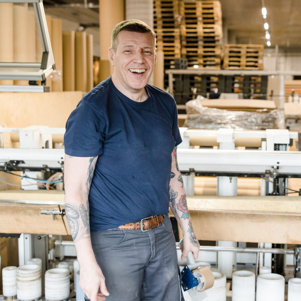 Mitarbeiter lacht bei der Arbeit in Produktion für Sprialrohre und Sprialkerne bei pratopac