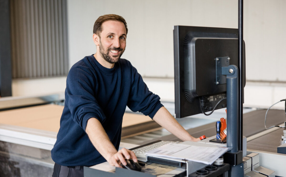 Maschinenführer vor Cutter für Kartonagen bei pratopac